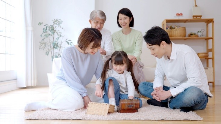 Grandparents, parents, and grandchild playing on floor.